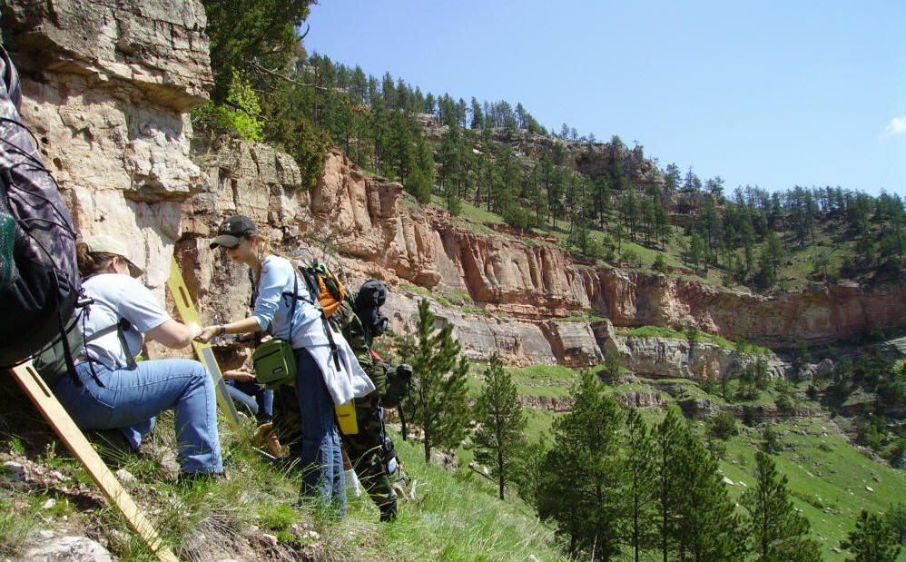Geological outcrop in the Black Hills — students mapping rock formations during field camp